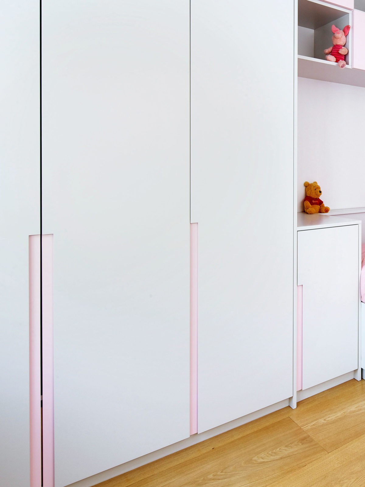 Lacquered wardrobe doors with pink handleless detail