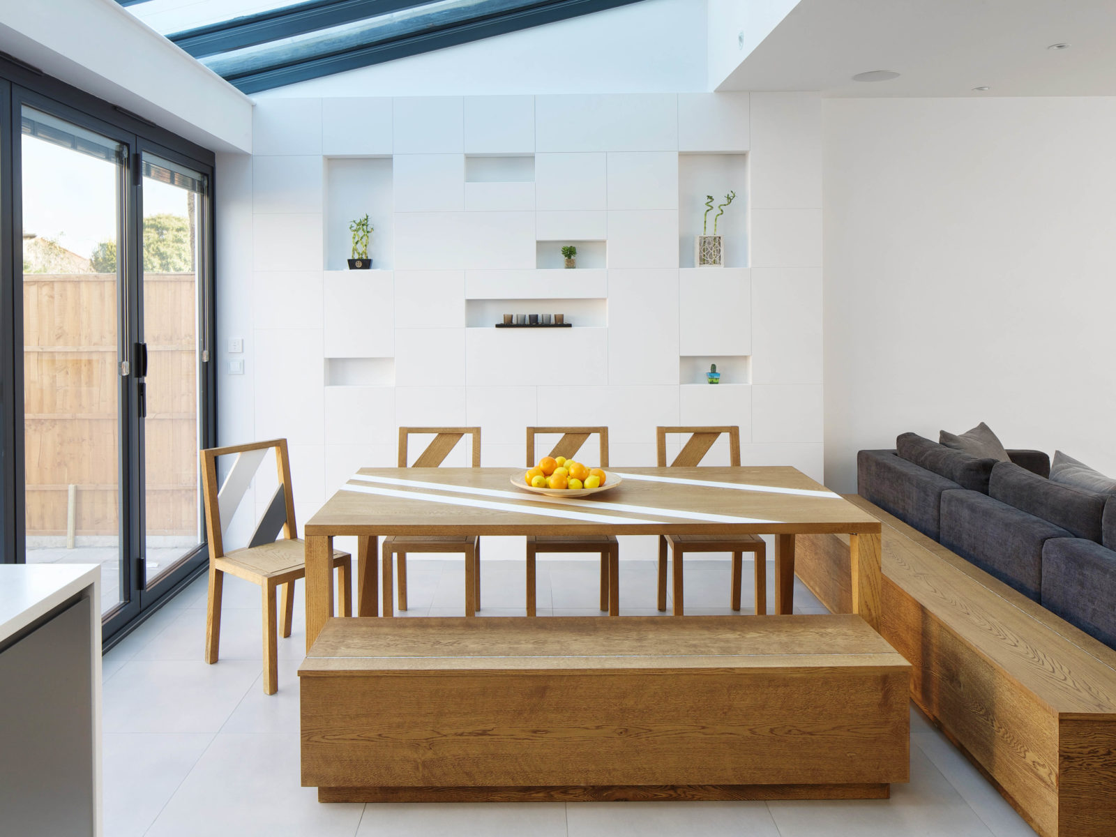 Dining space with bespoke oak and Corian dining table and benches