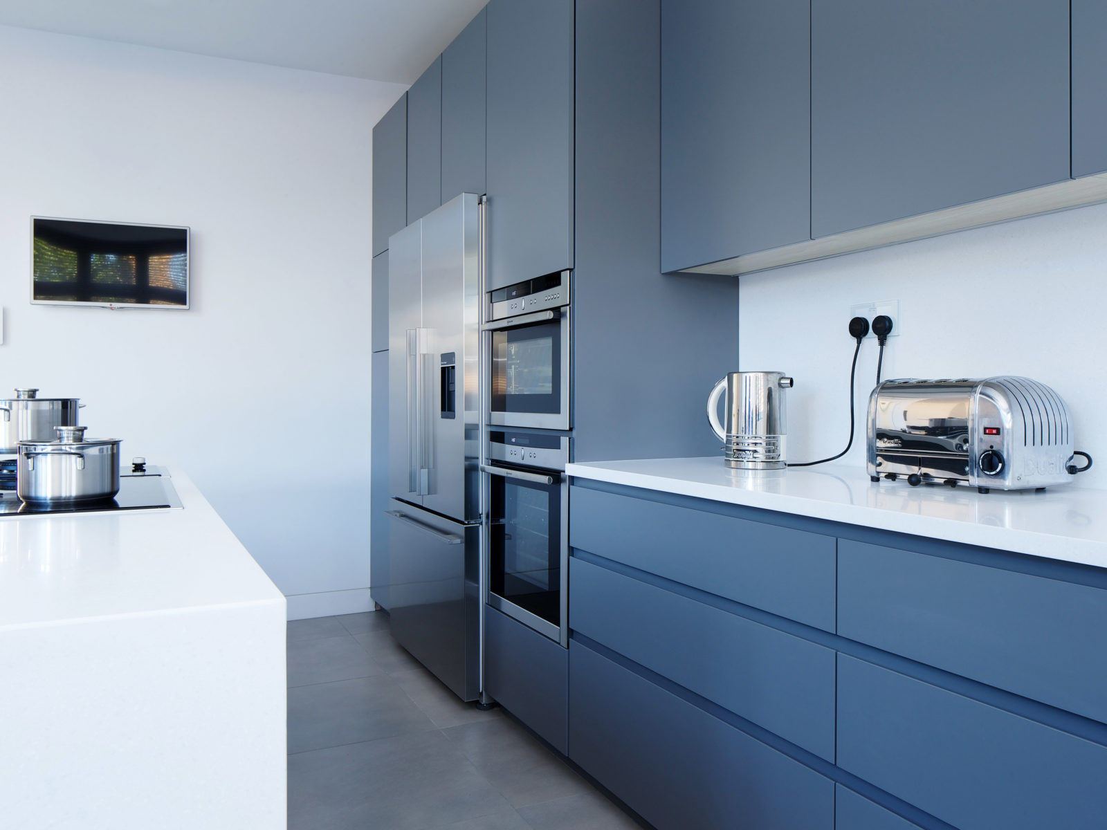 Grey matt lacquered kitchen with long handless drawers