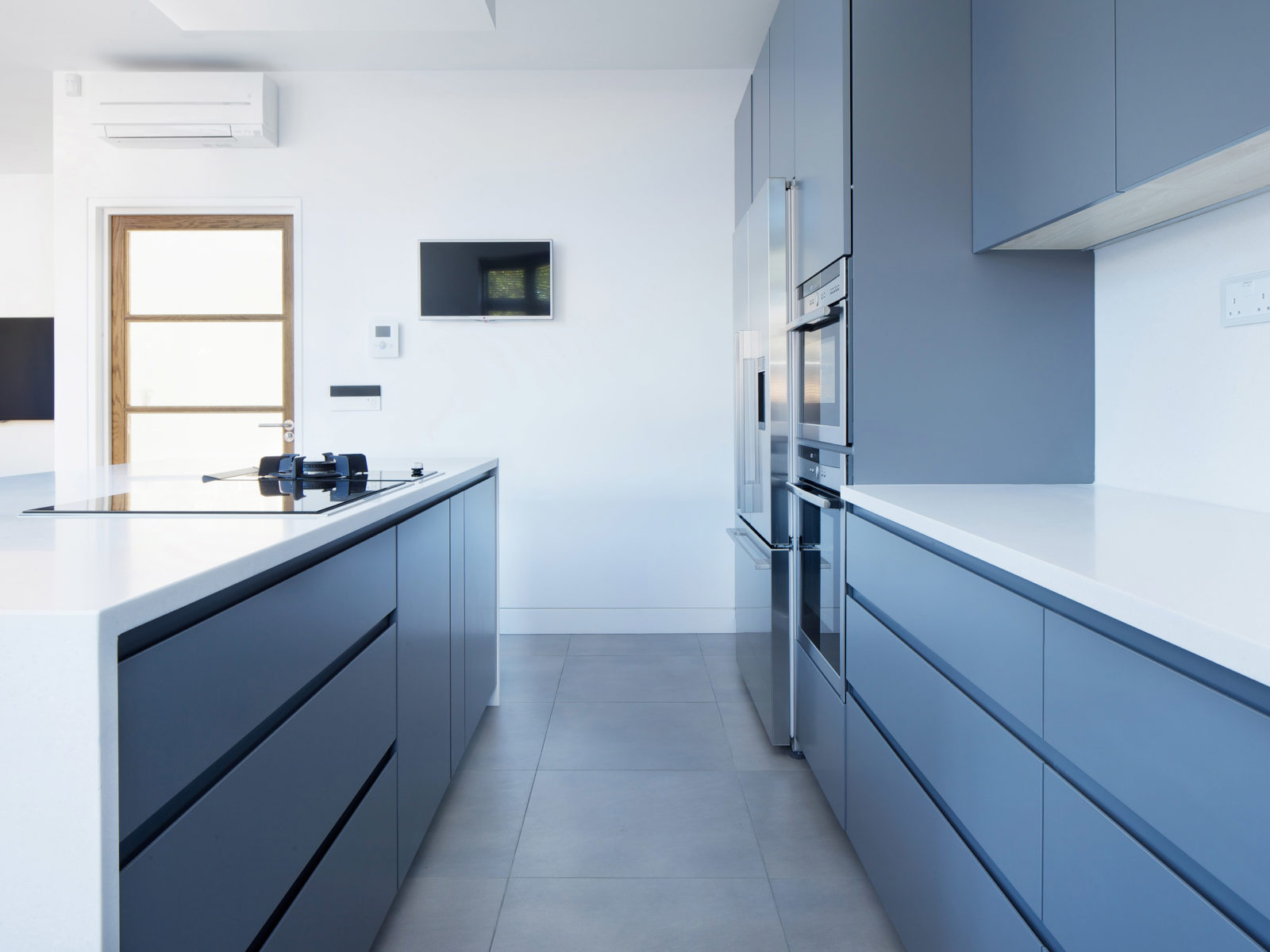 handleless matt lacquered kitchen with Corian worktop and integrated appliances