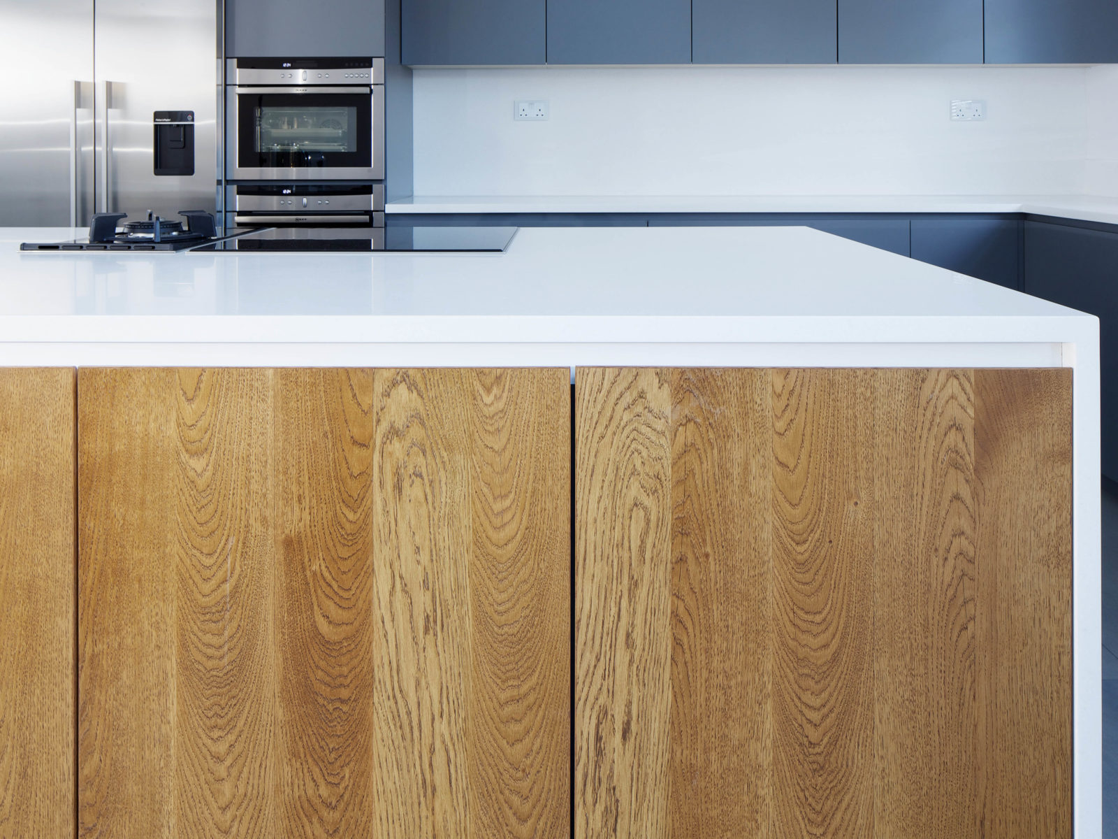 Handless kitchen island with solid oak doors and Antartica Corian worktop