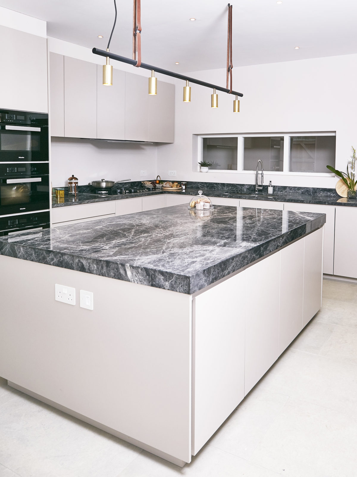 Matt lacquered kitchen island with thick Savana grey marble worktop