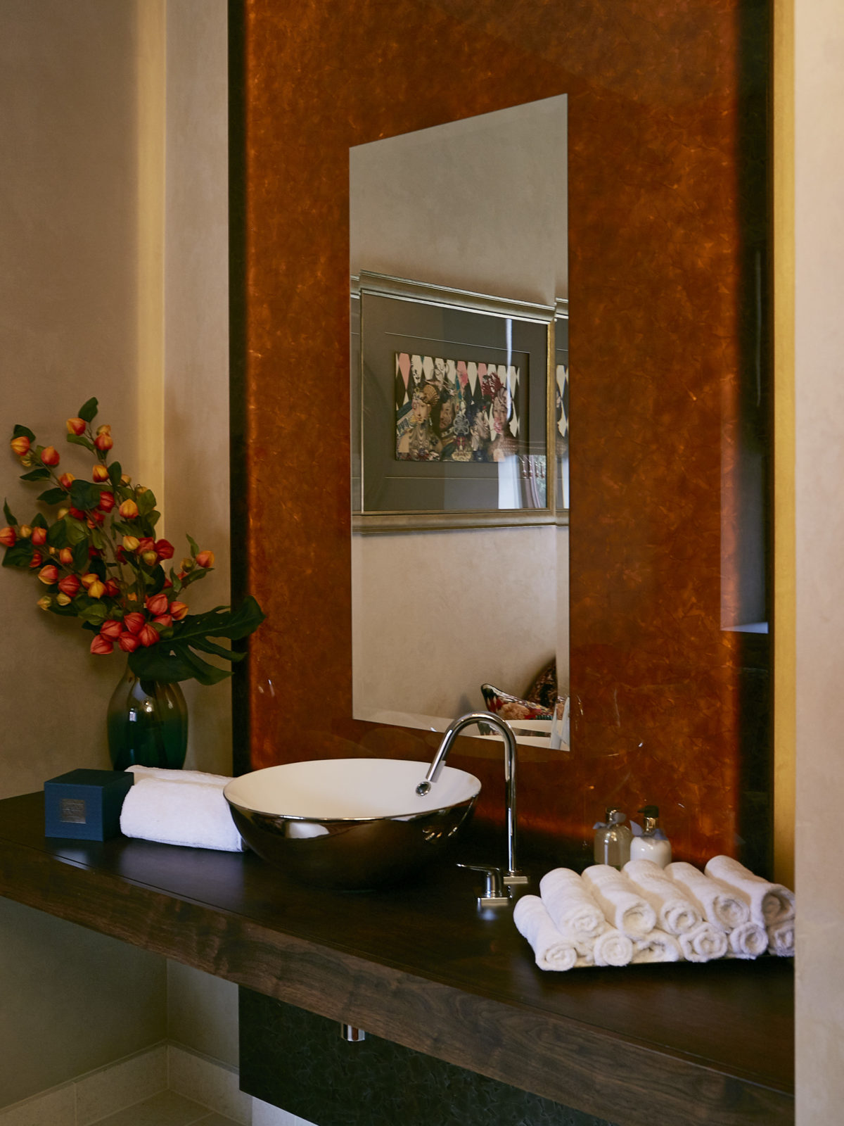 Walnut bathroom worktop with backlit recycled glass mirror wall