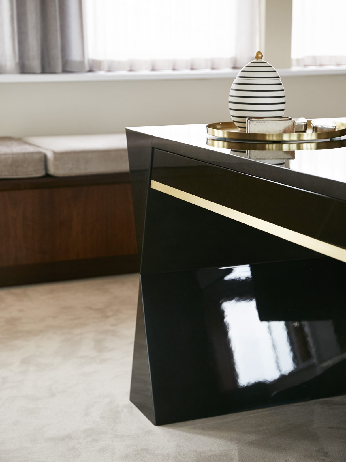 Gloss finish gun metal lacquered desk with satin brass drawer detail