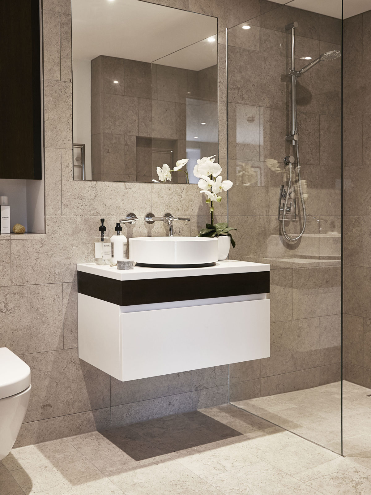 Moleanos limestone bathroom with white Corian and fumed oak vanity unit