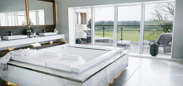 Calacatta marble bathroom with fumed oak vanity unit and book matched marble bath surround