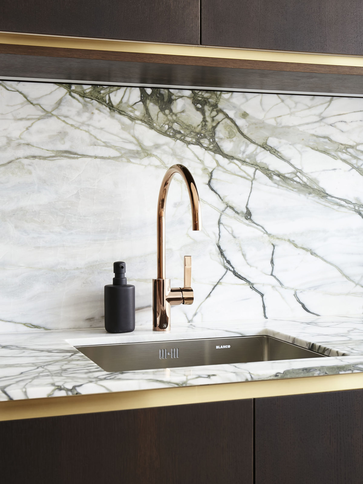 Calacatta marble worktop and splachback, dark wood kitchen cabinets and brass detailing