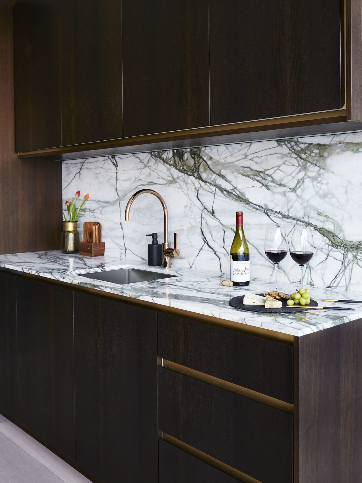 handleless fumed oak kitchen with satin brass strips